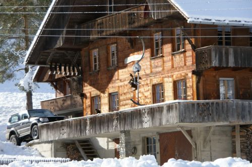 Uralte Baco-Skiliftbügel ziehen sanft am stattlichen Bauernhaus vorbei
