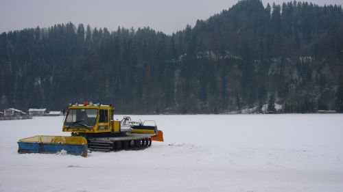 Eine einsame Stahl-Pistenmaschine (Schweizer Fabrikat!) steht beim Parkplatz
